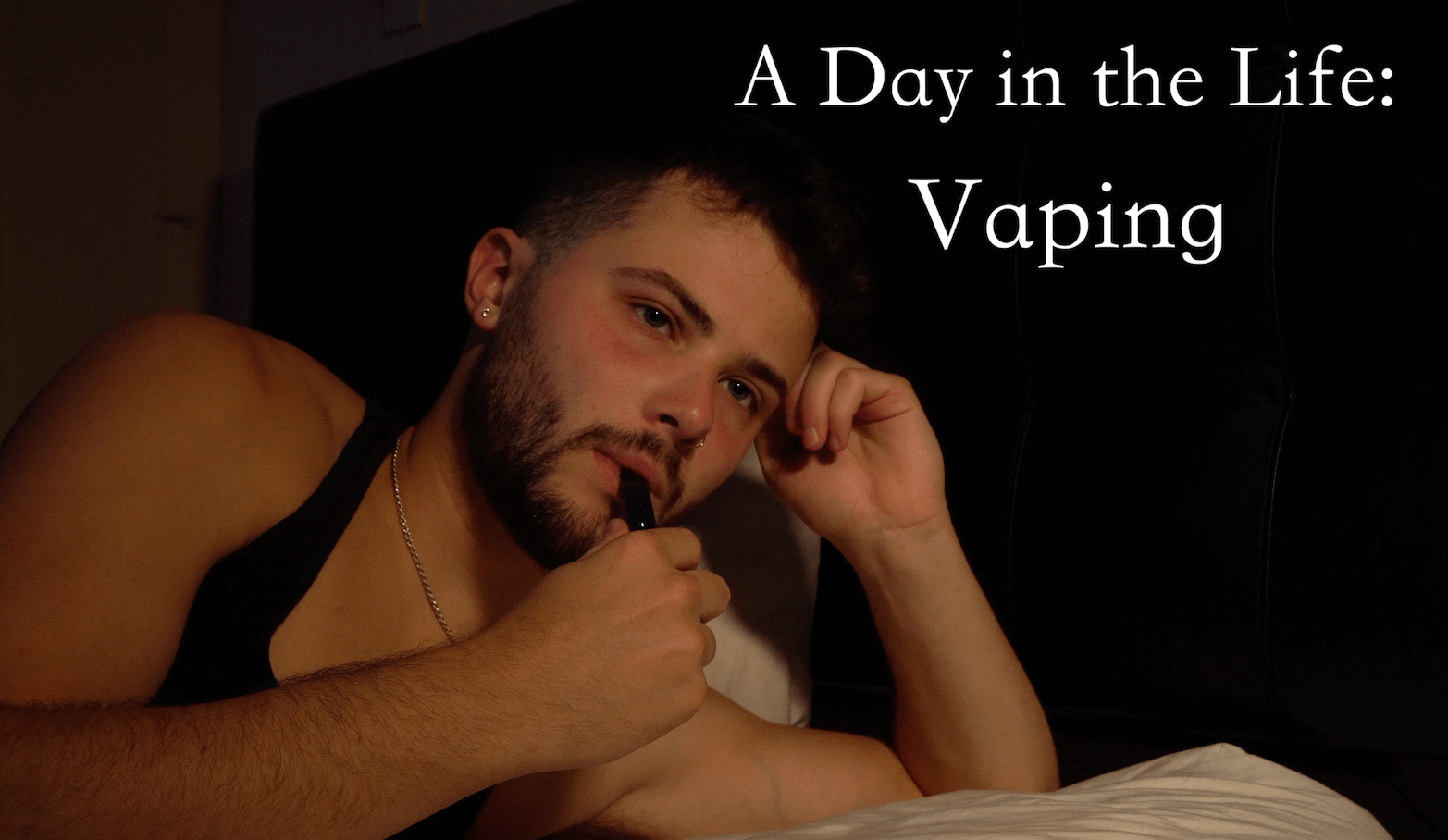A Day in the life Vaping. A Man in a tank top with his vape up to his lips. 